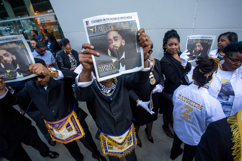 Attendees at Nipsey Hussle’s memorial service hold up copies of the Nation of Islam’s Final Call newspaper with Hussle on the cover April 11, 2019.